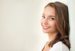 Woman leaning against a wall smiling