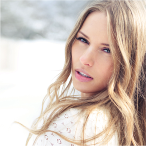 Woman with long blonde hair outdoors gazing intensely