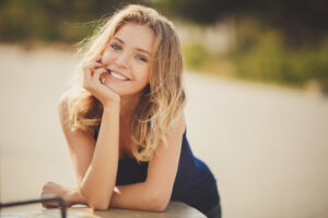 Young woman smiling and resting her head on her hand