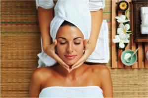 Woman with her eyes closed receiving a facial massage