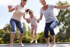 Mother, daughter and grandmother jumping on a trampoline