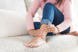 Woman pressing on her ankle