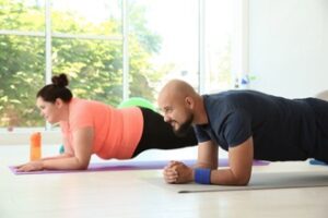 A man and a woman doing yoga indoors