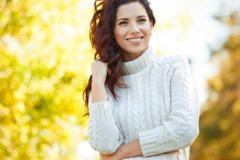 Woman smiling and wearing white sweater 