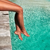 Woman dangling her legs over a pool ledge