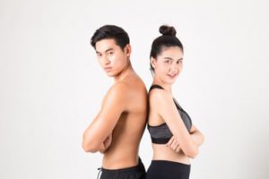 Skinny man and woman standing back-to-back