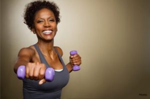Mature woman holding small weights and working out