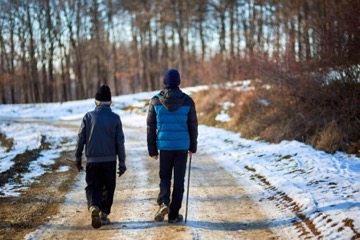 two people walking on a snowy path