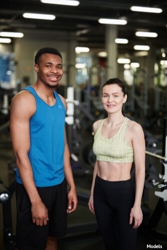 Man and woman in the gym wearing workout clothes