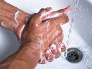 Close-up of hands being washed in the sink