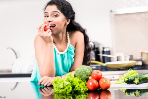 Woman eating veggies and fruits