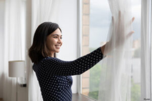 Woman opening her curtains