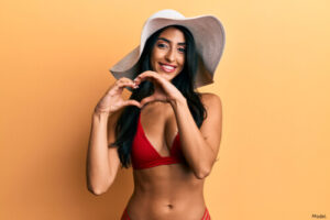 woman wearing a red bikini and making a hear twith her hands