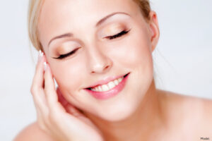 Serene woman smiling and touching her temple