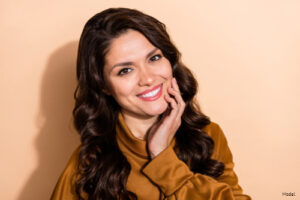 Joyful woman in an orange sweater smiling