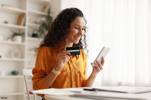 woman smiling, holding credit card