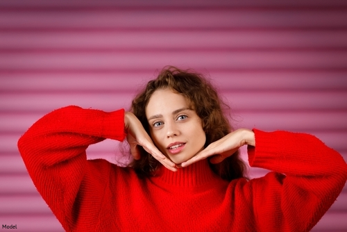 woman in a red sweater resting her chin on the backs of her hands