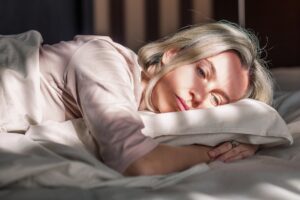 Woman lying on bed in emotional distress, highlighting how psychological stress, poor sleep, and emotional disorders may impact overall wellness and vein health
